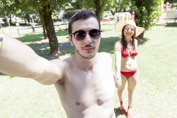 Jeune couple amoureux au bord de la piscine prend un selfie — Photo