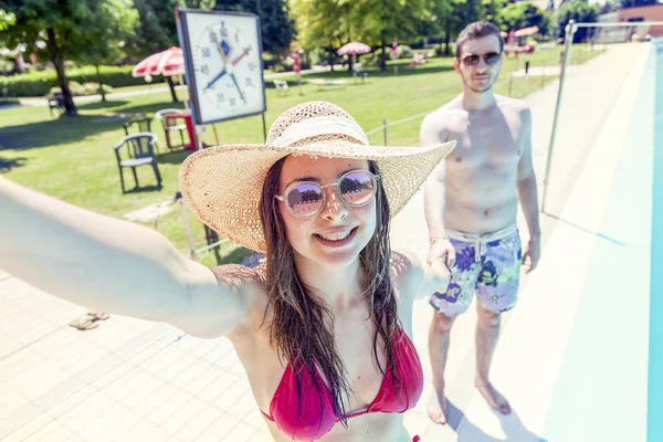 Joven pareja amorosa al lado de la piscina toma una selfie — Foto de Stock