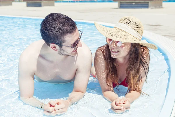 Joven pareja amante se relaja en el hidromasaje de la caca de natación — Foto de Stock