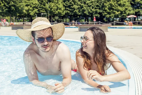 Joven pareja amante se relaja en el hidromasaje de la caca de natación — Foto de Stock