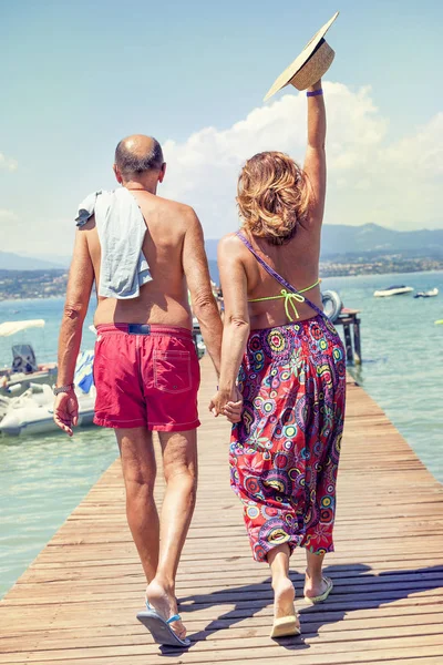 Moderna pareja madura relajándose en traje de baño caminando hacia atrás — Foto de Stock