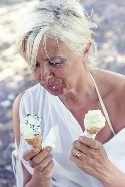 Красивая леди ест мороженое сидя на шезлонге — стоковое фото