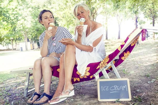 Mãe moderna e jovem filha comendo sorvete — Fotografia de Stock