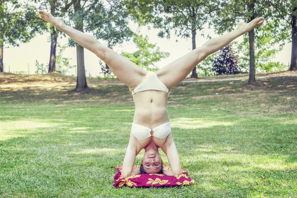 Jovem faz suportes em um parque público — Fotografia de Stock