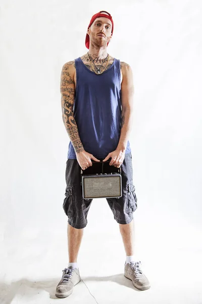 Tattooed rap singer posing in studio with an amplified radio — Stock Photo, Image