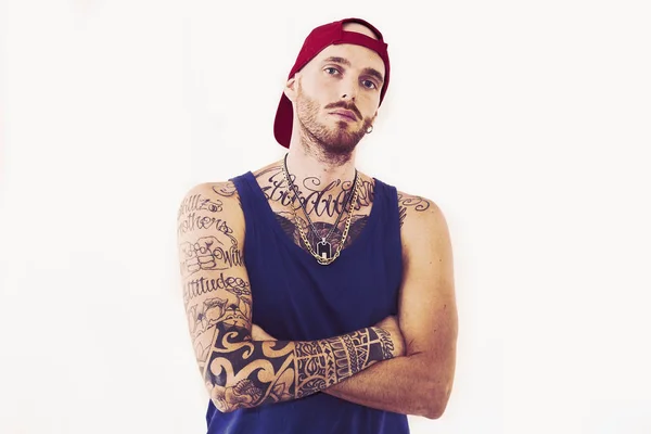 Tatuado cantante de rap posando en estudio sobre un fondo blanco — Foto de Stock