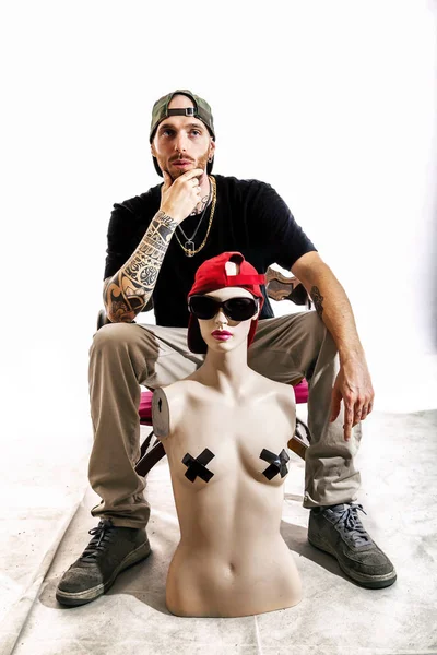 Cantante de rap tatuado posando en el estudio con un maniquí femenino — Foto de Stock