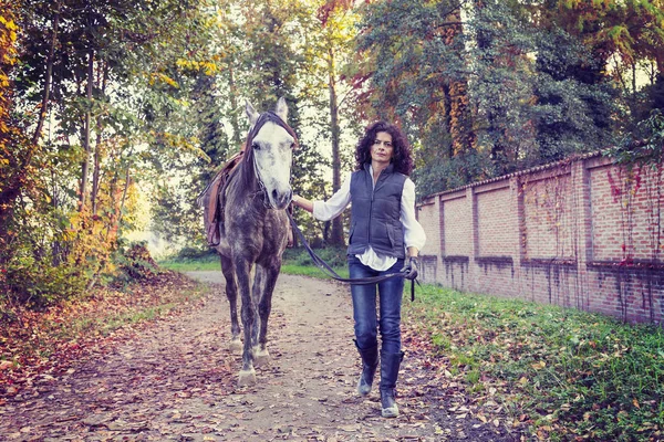 Horsewoman with his horse in the countryside — Stock Photo, Image