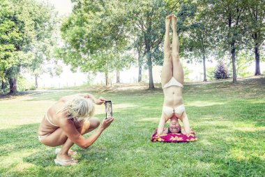 Anne kızı amuda yaparken fotoğraf çekimi