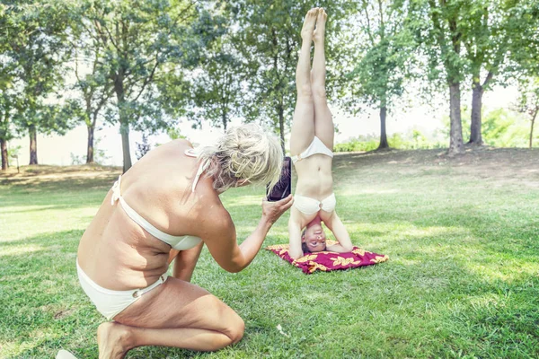 Mãe fotografar sua filha ao fazer o suporte — Fotografia de Stock