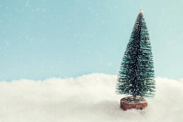 Árbol de Navidad en la nieve sobre fondo azul — Foto de Stock