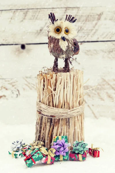 Miniatuur van uil over twijgen met gekleurde geschenken — Stockfoto