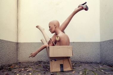bir karton kutu içinde yığılı kukla vücut parçaları