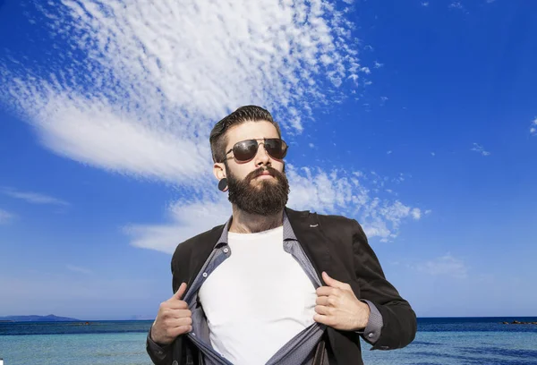 Jovem hipster super-herói em férias na frente de uma ilha no mar — Fotografia de Stock