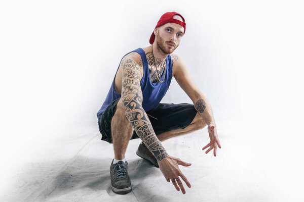 sitting tattooed rap singer posing in studio