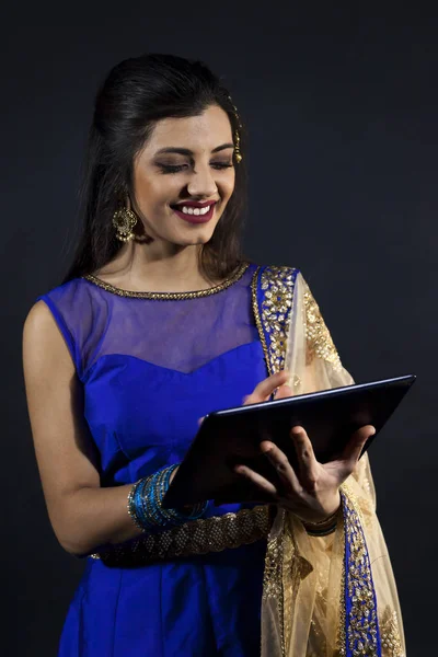 Sonriente hermosa india chica consultando su portátil —  Fotos de Stock