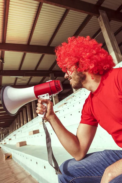 Sexy gekleed in rode kleur schreeuwen in de megafoon — Stockfoto