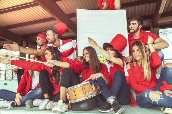 スポーツ イベントを見ている赤の色に身を包んだファンのグループ — ストック写真
