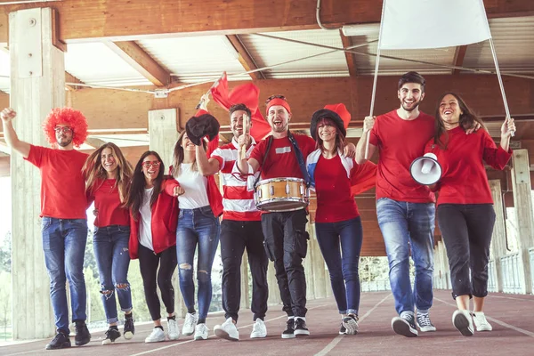 Gruppe rot gekleideter Fans läuft unter das Dach — Stockfoto