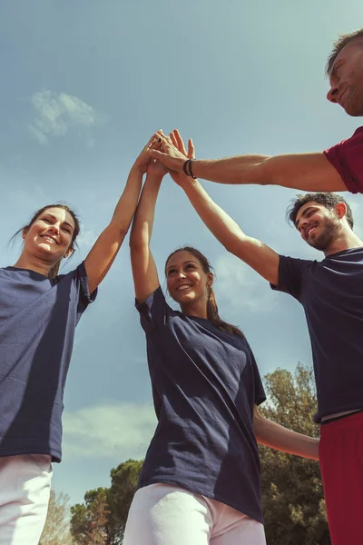 Círculo de jovens atletas esportivos felizes em sportswear levantando ha — Fotografia de Stock