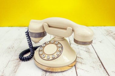 Beyaz ahşap bir masa Fildişi renkli vintage telefonla