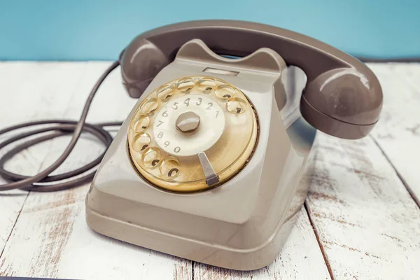 Brązowe kolorowe vintage telefon nad biały drewniany stół — Zdjęcie stockowe