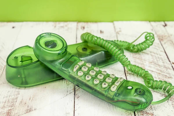 Green colorful vintage telephone over a white wooden table — Stock Photo, Image