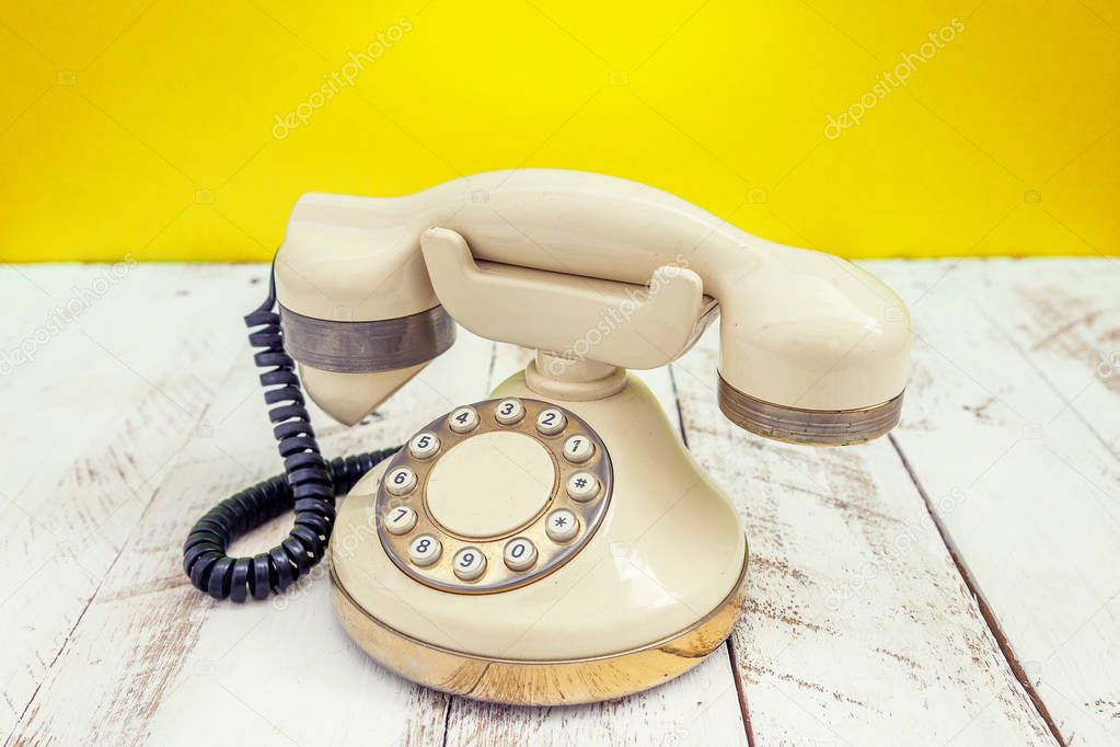 ivory colorful vintage telephone over a white wooden table