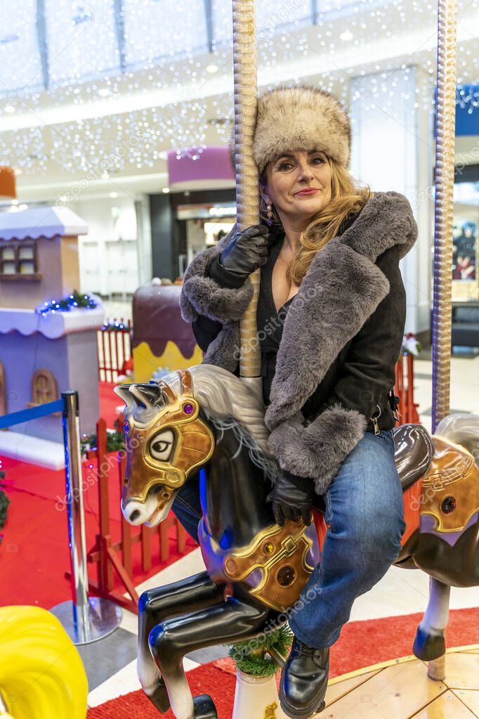 attractive mature woman while having fun on a carousel of horses