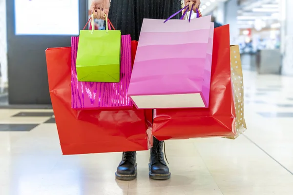 Žena ukazuje barevné nákupní tašky v obchoďáku — Stock fotografie
