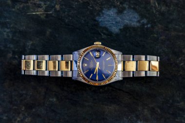 Rolex İstiridye Mavi saati kayaların arkasında