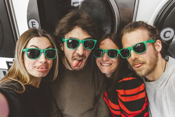 Group of young friends wearing green sunglasses having fun takin — 스톡 사진