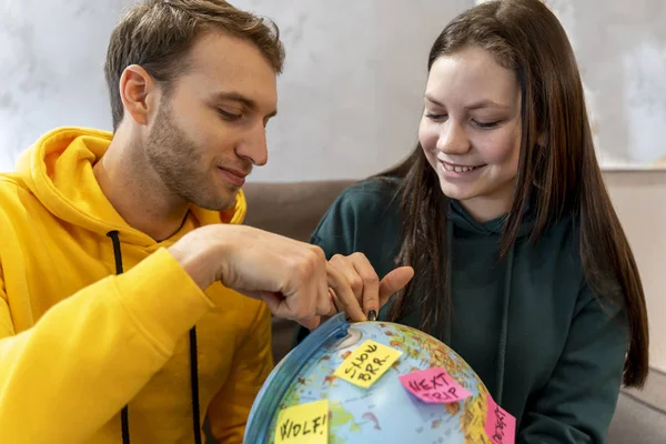 Młoda Para Planuje Następną Podróż Wybierając Cel Mapie Globu Koncepcja — Zdjęcie stockowe