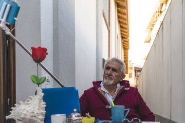 Yetişkin bir adam, koronavirüs acil durumu sırasında dışarıda kahvaltı ederken selfie çeker.