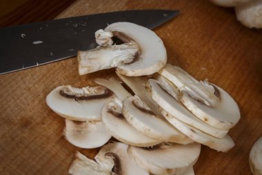 Bir kesme tahtası üzerinde mutfakta dilimlenmiş mantar