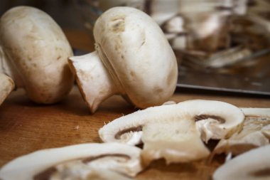 Bir kesme tahtası üzerinde mutfakta dilimlenmiş mantar