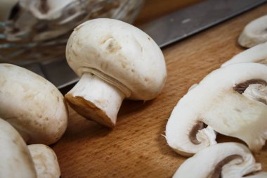 Bir kesme tahtası üzerinde mutfakta dilimlenmiş mantar