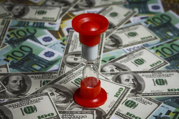 Dolar ve euro yığını üzerinde kum saati