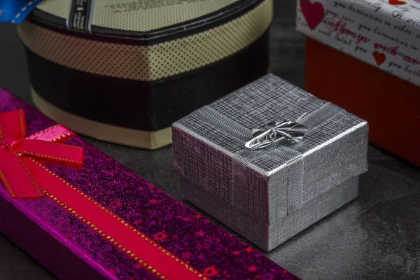 Koyu ahşap bir masa üzerinde çok renkli hediyeler