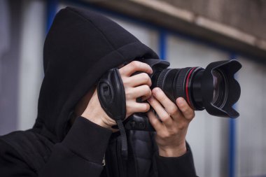 Genç bir adam, paparazzi, sokakta fotoğraf çekiyor.