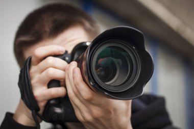Genç bir adam, paparazzi, sokakta fotoğraf çekiyor.