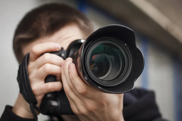 Genç bir adam, paparazzi, sokakta fotoğraf çekiyor.