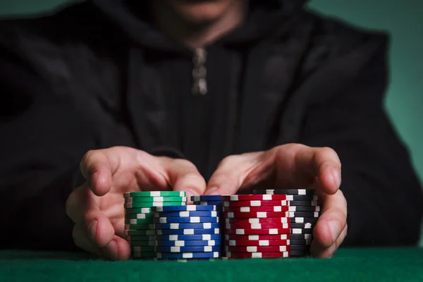 Siyah kazak giyen tüm fişleri poker koyar.