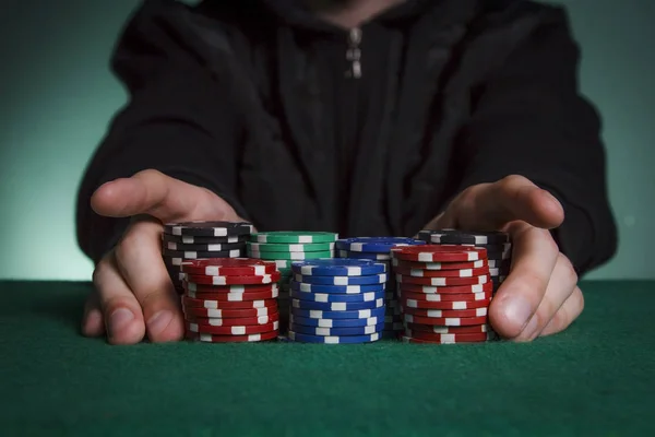 Siyah kazak giyen tüm fişleri poker koyar.