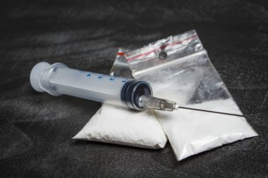 Beyaz toz ilaçlara benzer ile plastik torbalar üzerindeki şırınga