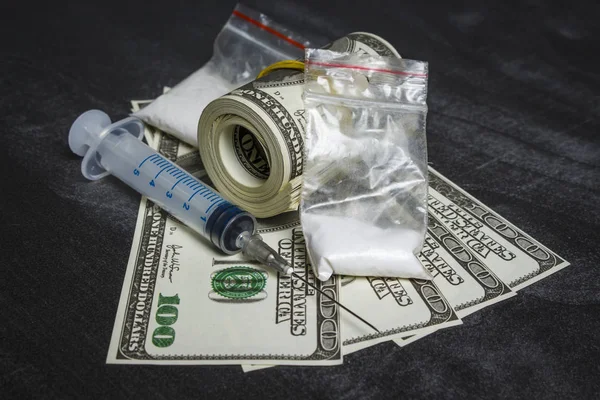 Şırınga ve uyuşturucu ile plastik torbalar dolar yığını yakın: