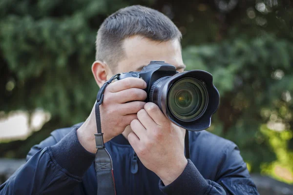 Un joven con una cámara toma fotos de la naturaleza —  Fotos de Stock