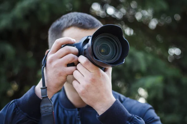 Un joven con una cámara toma fotos de la naturaleza —  Fotos de Stock