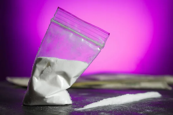 Pembe bir arka plan üzerinde beyaz toz plastik torba