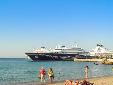 Mandraki limanından turistler ve dev bir yat